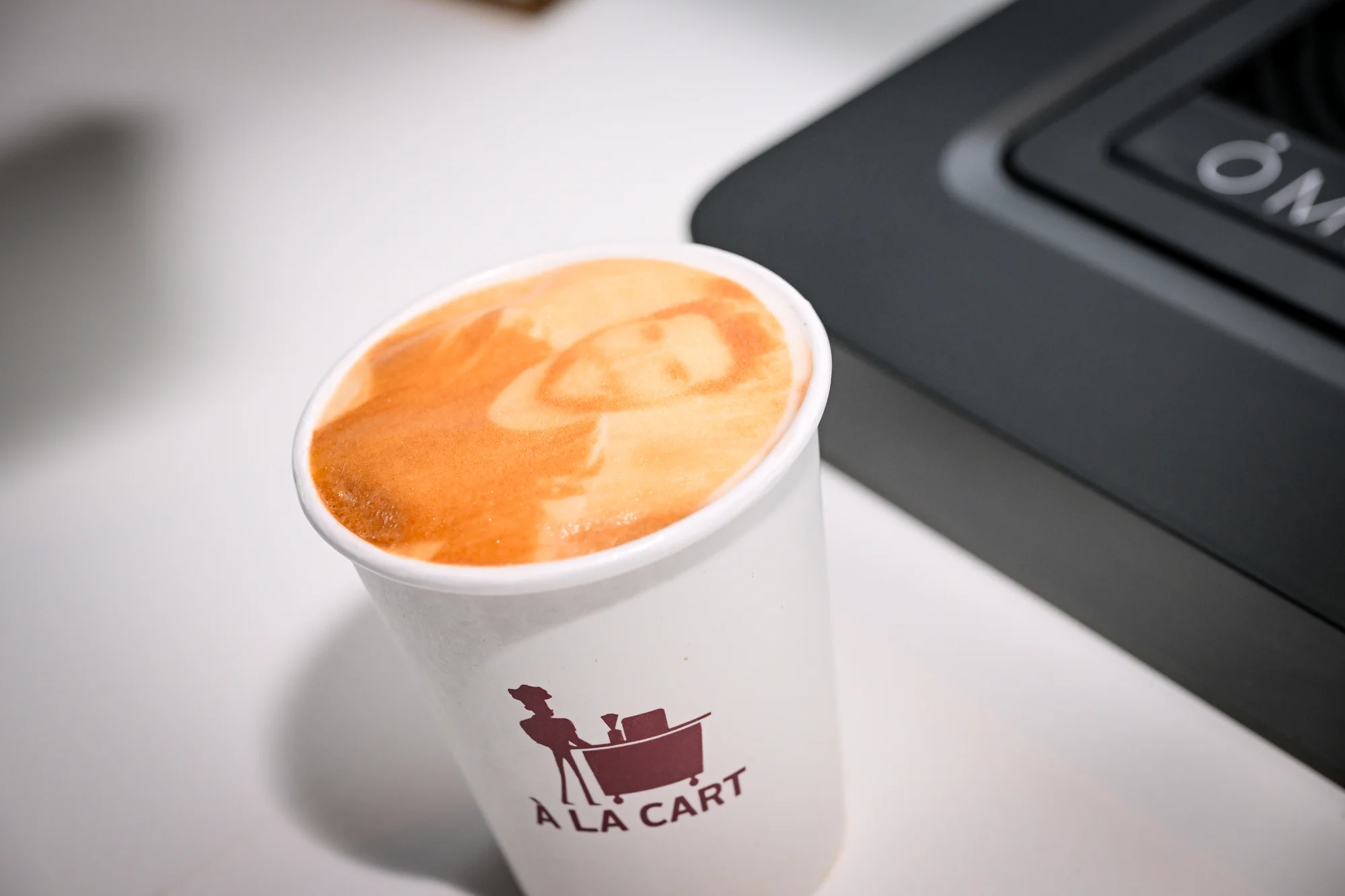 Closeup of a printed coffee. It has been printed with a selfie of a man.