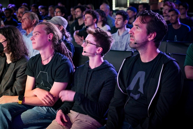 The front row of Astro team members watching the keynote speaker speak on stage.