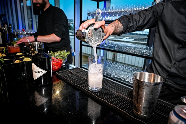 Closeup of a bartender pouring a drink after shaking it.