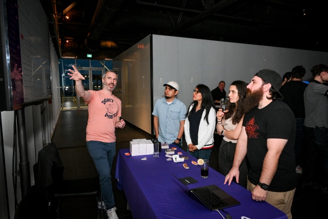 Sentry demos their product to a group of guest onlookers at their sponsor booth.